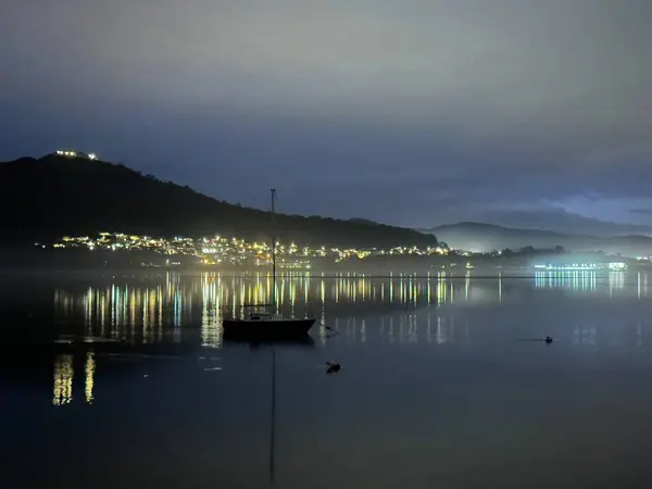 İspanyol sahil ışığı yansıyan tekne Minho nehrine yanaştı, Caminha, Viana do Castelo, Portekiz, Ocak 2024