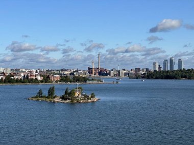Arka planda Helsinki şehri panoraması olan küçük kayalık bir ada, Uusimaa, Finlandiya, Ağustos 2023