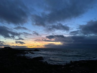 Güneş battıktan bir saat sonra Atlantik Okyanusu 'nun kayalık kıyısında A Guarda, İspanya, Aralık 2023