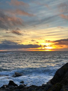 A Guarda, Galiçya, İspanya yakınlarındaki Atlantik Okyanusu 'nun kayalık kıyılarında gün batımı, Aralık 2023