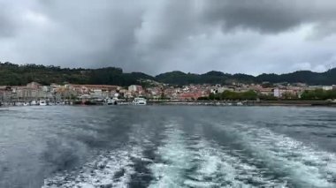 Ria de Vigo halklarının, Cangas şehrinin ve çevresindeki dağların 2024 Nisan 'ında Galiçya' dan kalkan feribotun manzarası.