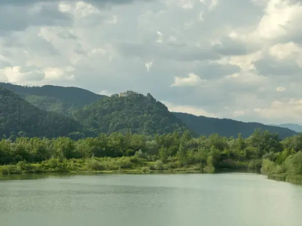 Povask Bystrica, Trenn, Slovakya, Mayıs 2024 yakınlarında bulutlu bir gökyüzünün altındaki Vh nehrinin manzarası
