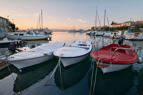 Günbatımında Krk adasındaki Hırvatistan 'ın Malinska kasabasında demirli tekneli Marina