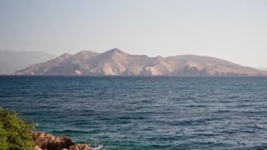 Hırvatistan 'ın Krk adasındaki Baska kasabası yakınlarındaki Adriyatik Denizi' nde ıssız bir adanın manzarası