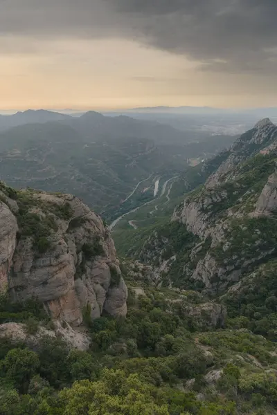 İspanya 'daki Montserrat sıradağları Katalan Dağları' ndaki Barcelona yakınlarında. Arkasında vadi olan dağ manzarası. Dikey görünüm