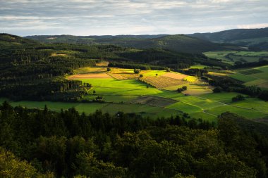 Almanya 'nın Olsberg kentindeki Bruchhauser Steine' dan gün batımında görülen Sauerland manzarası. Güzel aydınlatılmış tarlalar ve arka planda dağlar