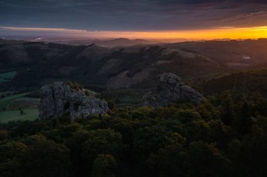 Almanya 'nın Sauerland bölgesinin ön planında Bruchhausen Steine Kayaları ile dramatik bir gündoğumu sırasında manzarası