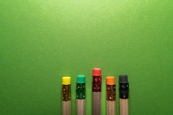 緑の背景にカラフルな消しゴム付きの木製の鉛筆 — ストック写真