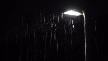 Heavy rain with a glowing street lantern at night