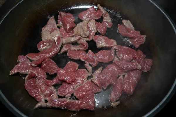 牛肉片加盐和胡椒在锅里油炸 — 图库照片