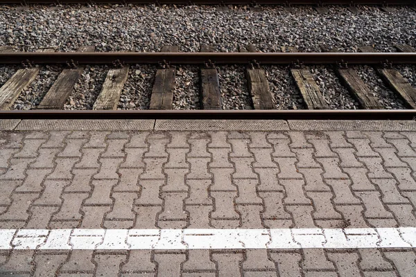 Bahnsteig Mit Pflastersteinen Und Bahngleisen — Stockfoto