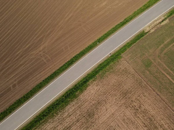 耕作した農地と景観中の土壌との間のアスファルト道路の空中ビュー — ストック写真