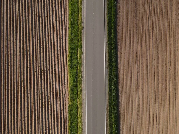 耕作地と土壌との間の直線アスファルト道路の空中ビュー — ストック写真
