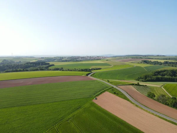 緑豊かな農業地帯 アスファルト道路 初夏の青空が広がる空中風景 — ストック写真