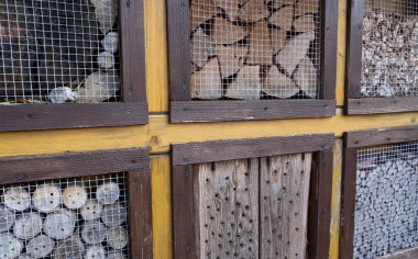 Birçok deliği ve farklı odunları olan böcek oteli.