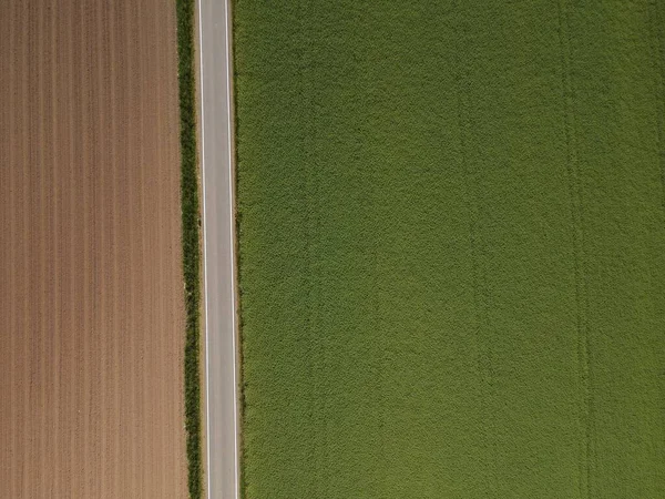 Uitzicht Van Bovenaf Een Landbouwveld Met Bruine Grond Een Asfaltweg — Stockfoto