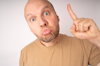 Genç adam gözlerini açar, dudaklarını şişirir ve işaret parmağını kaldırır çünkü iyi bir fikri ve iyi bir çözümü vardır.