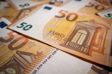 Arkaplanda 50 Euro 'luk banknotlar var.