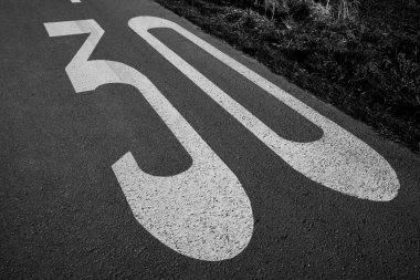 Siyah beyaz bir yolda hız sınırı için 30 numara 