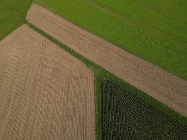 Tarla tarlaları, tarla sürülmüş toprak, yeşil mahsul ve çimlerin insansız hava aracı görüntüsü