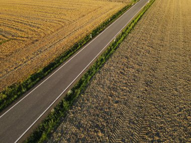 Arazideki tarım arazileri arasındaki bir yolun havadan görünüşü 