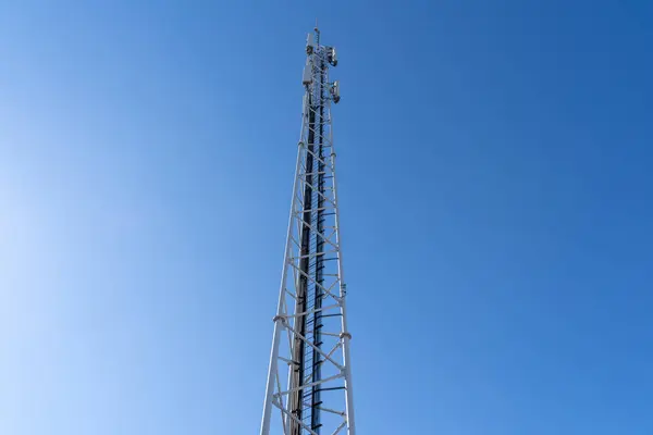 Phone and internet tower with antennas in the blue sky