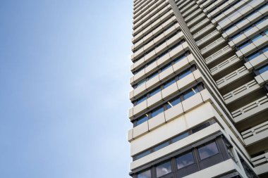 Arka planda mavi güneşli gökyüzü olan büyük ofis binası.