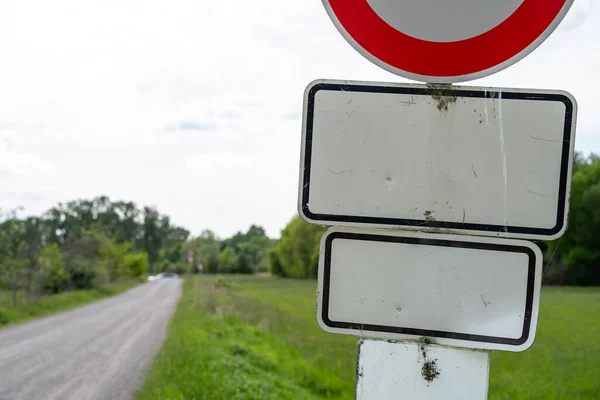 Empty road signs on a gravel road in the countryside