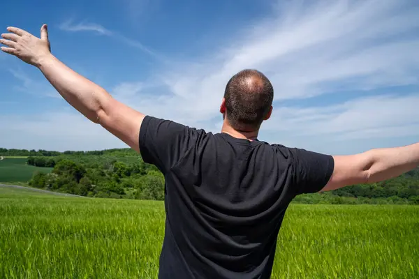 Man with open arms in the countryside