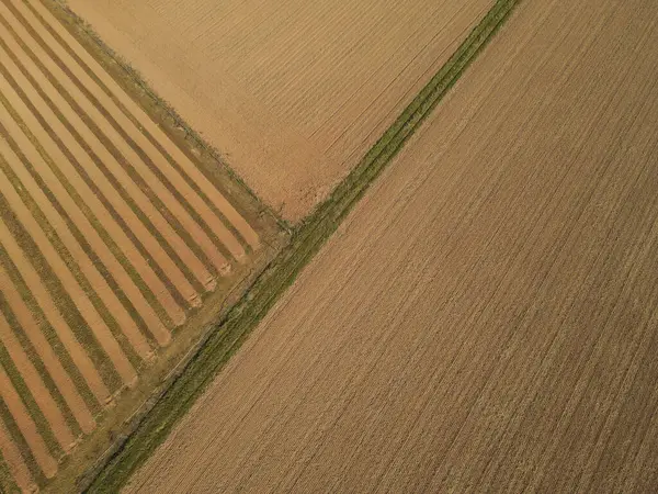 View from above of plowed farm fields with soil in the countryside