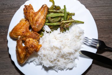 Izgara tavuk kanadı, kızarmış yeşil fasulye ve haşlanmış pilav.