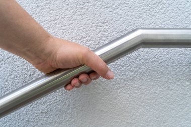 Apartman girişinde paslanmaz çelik korkuluklu bir el.