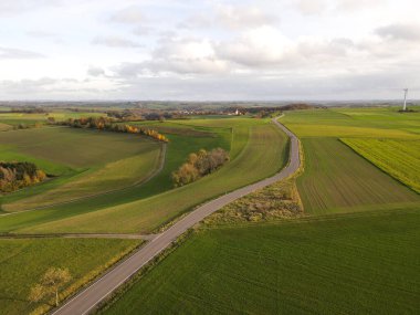 Sonbaharda tarımsal tarlalar arasındaki yolun üstünden bak