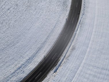 Kış ortasında biraz sisli kıvrımlı bir yolun havadan görünüşü 