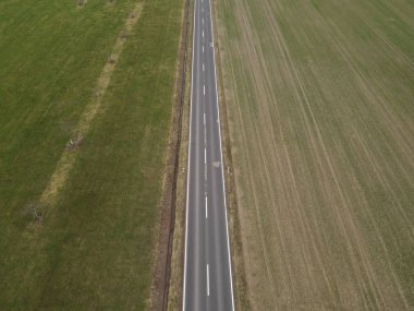 İlkbaharda kırsal bölgelerdeki tarlalar arasındaki bir yolun havadan görünüşü