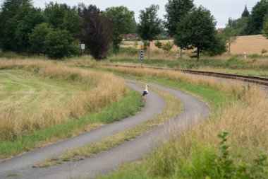 Kırsal bir yolu ve beyaz leyleği olan manzara.