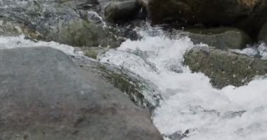 Nehir akıntısının nehir kayalıklarında ağır çekimde akan detaylarını kapat.