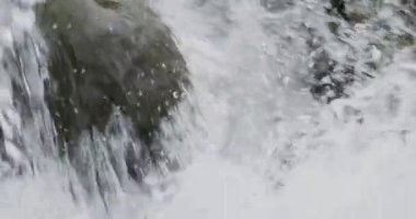Nehir akıntısının nehir kayalıklarında ağır çekimde akan detaylarını kapat.