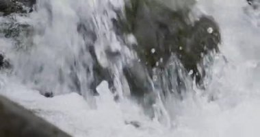 Nehir akıntısının nehir kayalıklarında ağır çekimde akan detaylarını kapat.