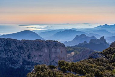 Alicante sahilinden Sierra del Malladar 'da gün batımı. Sağdaki Castellet Dağları. Alicante ilinde, Benimantell, İspanya.