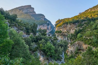 Ordesa Doğal Parkı, Huesca, Aragon, İspanya 'da yüksek kayalık dağlar ve yeşil ormanlarla Anisclo Kanyonu' nda günbatımı.