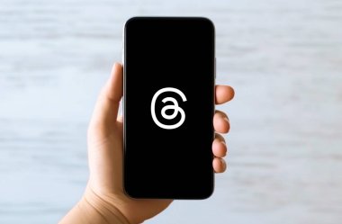 Sosyal medya logo simgesi, akıllı telefon arayüzü içeren el ele tutuşan telefon