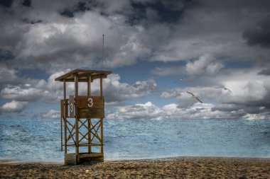 Huzurlu bir sahil sahilinde Martılarla Uçan Cankurtaran Kulesi
