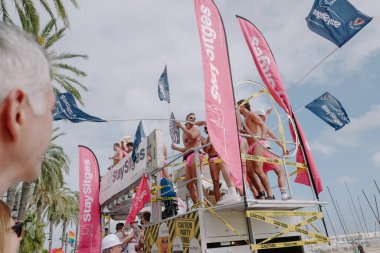 Sitges, İspanya - 8 Haziran 2025: Kalın kostümlü katılımcılar Sitges Onur Yürüyüşü sırasında renkli bir şamandırada dans edip tezahürat yapıyorlar. Festival sahnesi özgürlüğü, çeşitliliği ve LGBTQ + gururu kutluyor.