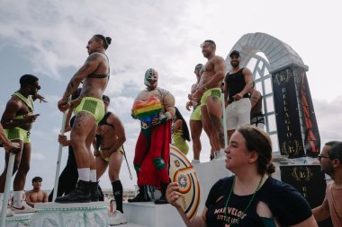 Sitges, İspanya - 8 Haziran 2025: Kalın kostümlü katılımcılar Sitges Onur Yürüyüşü sırasında renkli bir şamandırada dans edip tezahürat yapıyorlar. Festival sahnesi özgürlüğü, çeşitliliği ve LGBTQ + gururu kutluyor.