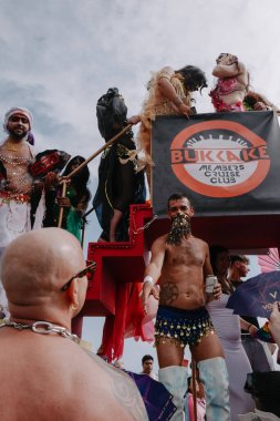 Sitges, İspanya - 8 Haziran 2025: Kalın kostümlü katılımcılar Sitges Onur Yürüyüşü sırasında renkli bir şamandırada dans edip tezahürat yapıyorlar. Festival sahnesi özgürlüğü, çeşitliliği ve LGBTQ + gururu kutluyor.