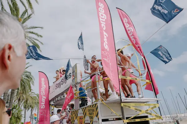 Sitges, İspanya - 8 Haziran 2025: Kalın kostümlü katılımcılar Sitges Onur Yürüyüşü sırasında renkli bir şamandırada dans edip tezahürat yapıyorlar. Festival sahnesi özgürlüğü, çeşitliliği ve LGBTQ + gururu kutluyor.