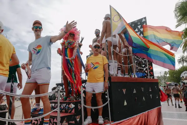 Sitges, İspanya - 8 Haziran 2025: Kalın kostümlü katılımcılar Sitges Onur Yürüyüşü sırasında renkli bir şamandırada dans edip tezahürat yapıyorlar. Festival sahnesi özgürlüğü, çeşitliliği ve LGBTQ + gururu kutluyor.
