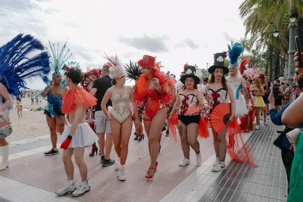 Sitges, İspanya - 8 Haziran 2025: İnsanlar Sitges Onur Yürüyüşü sırasında gökkuşağı bayrakları sallayarak renkli kıyafetler içinde sevinçle yürüyorlar. Kalabalık deniz kenarında aşkı, çeşitliliği ve LGBTQ + gururunu kutluyor.