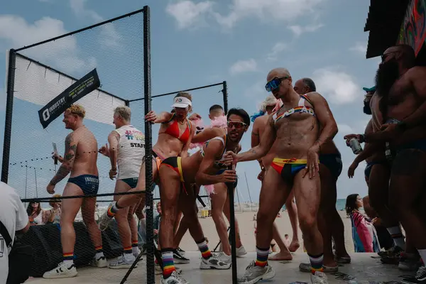 Sitges, İspanya - 8 Haziran 2025: Kalın kostümlü katılımcılar Sitges Onur Yürüyüşü sırasında renkli bir şamandırada dans edip tezahürat yapıyorlar. Festival sahnesi özgürlüğü, çeşitliliği ve LGBTQ + gururu kutluyor.